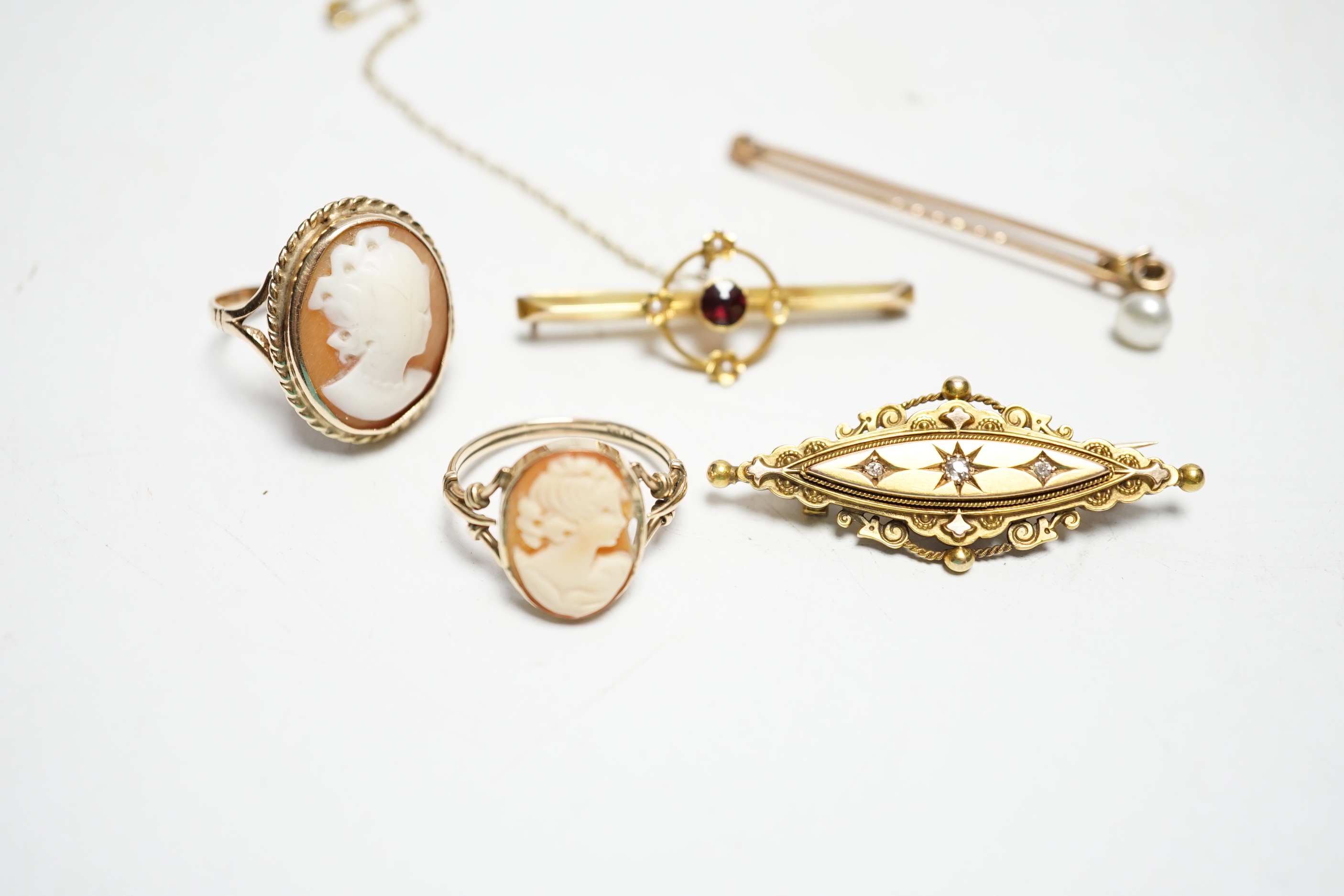 A late Victorian 15ct gold and three stone diamond chip set brooch, 43mm, an early 20th century yellow metal, garnet and seed pearl set bar brooch, two 9ct and oval cameo shell set rings and a yellow metal and cultured p